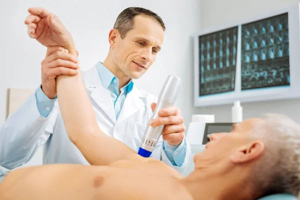 Médico profissional do sexo masculino dobrando o braço de seus pacientes — Fotografia de Stock