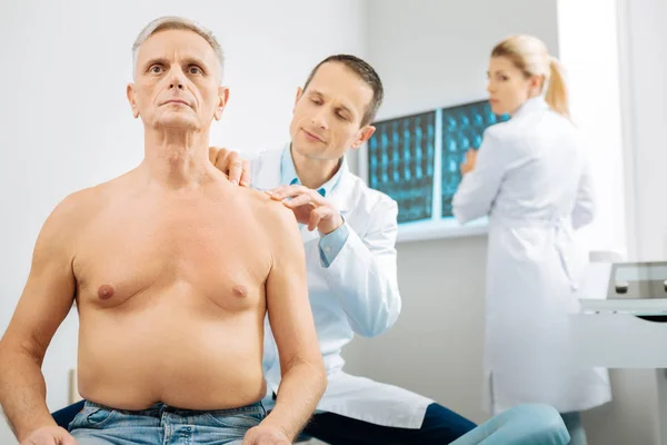 Terapeuta masculino inteligente trabajando con su paciente anciano — Foto de Stock