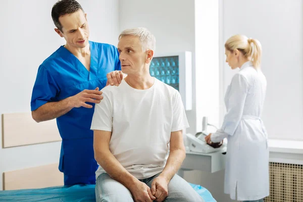 Guapo buen hombre tocando sus pacientes hombro — Foto de Stock