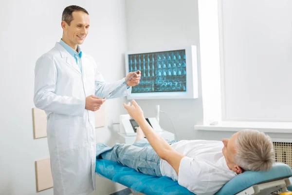 Alegre bom médico segurando uma foto de raio-X — Fotografia de Stock