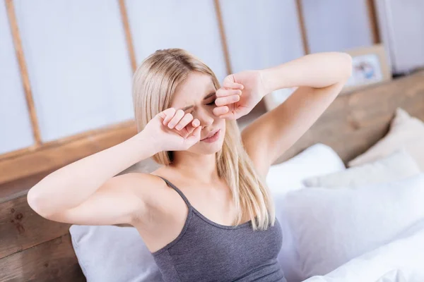 Joven mujer frotándose los ojos después de haber despertado —  Fotos de Stock