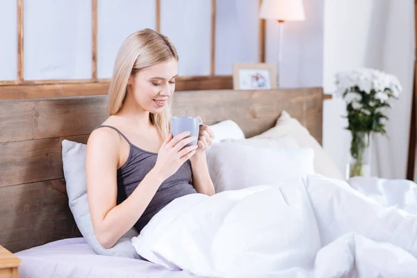 Hermosa joven sentada en la cama y tomando café — Foto de Stock