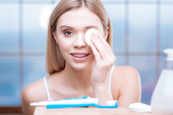 Mujer hermosa eliminación de maquillaje de ojos con almohadilla de algodón — Foto de Stock