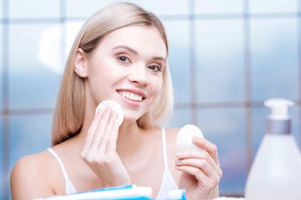 Mujer animada limpiando su piel con almohadillas de algodón — Foto de Stock