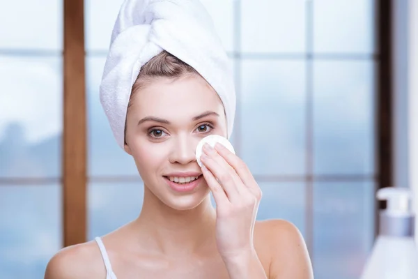 Mooie vrouw in de handdoek-tulband oog make-up verwijderen — Stockfoto
