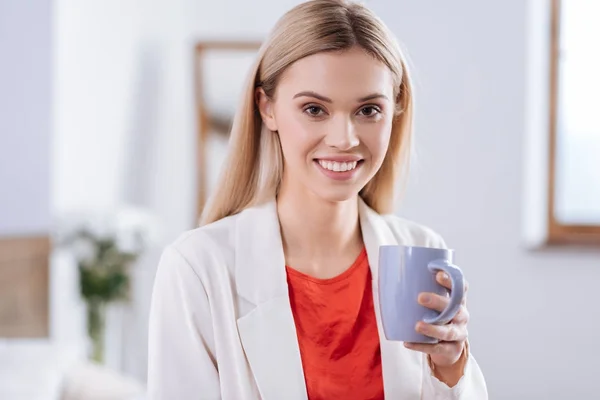 Vrolijke vrouw in rode blouse koffie drinken — Stockfoto