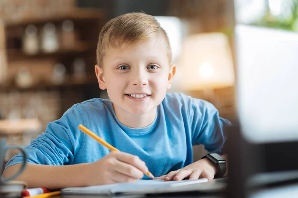 Fröhlich entzückter Junge macht sich Notizen — Stockfoto