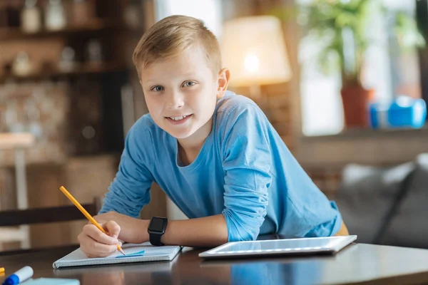 Alegre chico inteligente apoyado en la mesa — Foto de Stock