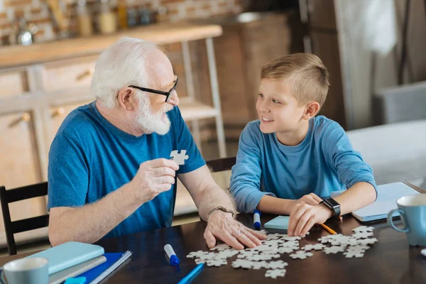 Joyful nice man collecting jigsaw puzzles — Stock Photo, Image