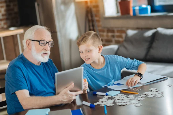 Joyful nice boy pointing at the tablet — Stock Photo, Image