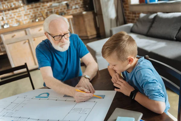 Pozitivní chytrý chlapec pozoruje jeho dědeček, pracovní — Stock fotografie