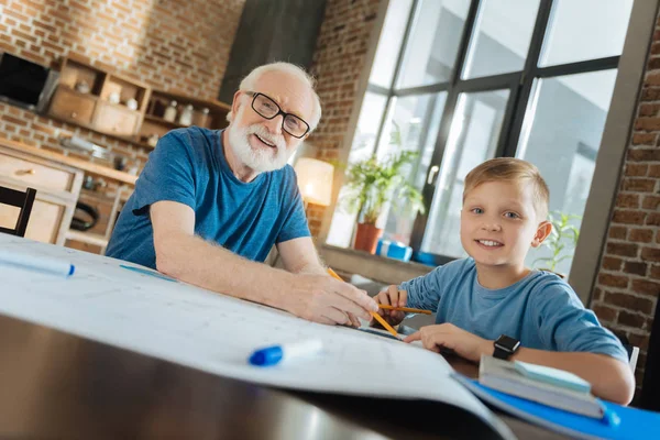 Веселый дедушка и внук работают над рисунком — стоковое фото