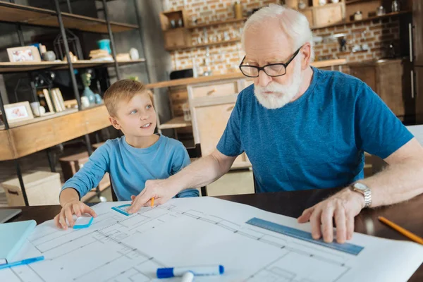 Professional aged engineer working with his grandson — Stock Photo, Image