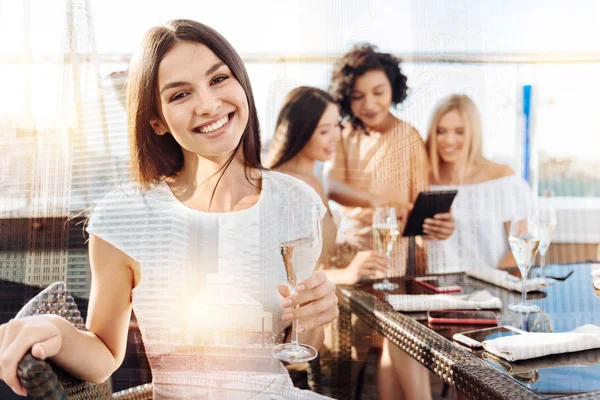 Bir bardak şampanya tutan güzel mutlu kadın