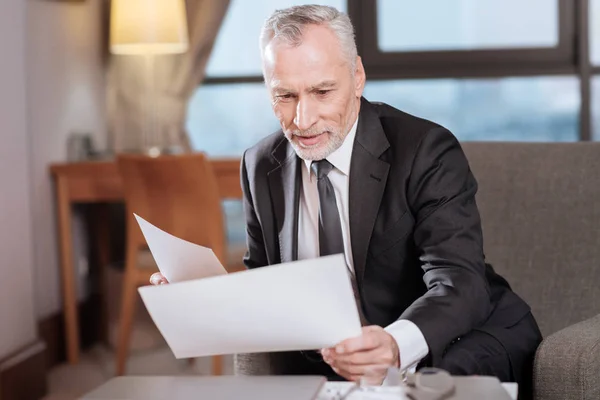 Старший опытный бизнесмен просматривает документы — стоковое фото