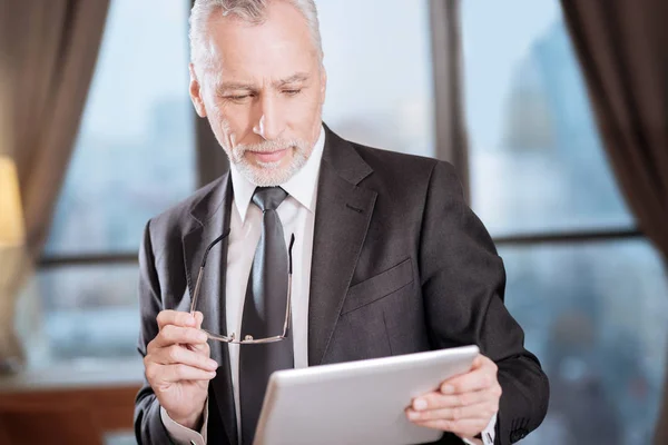 Hombre mayor guapo chequeando informe — Foto de Stock