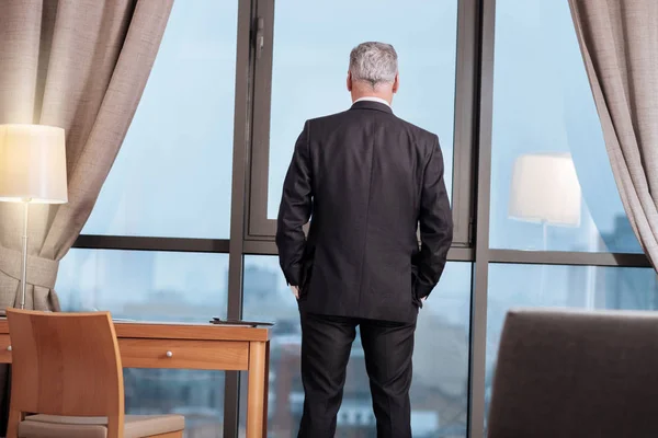 Hombre de negocios ambicioso mirando por la ventana — Foto de Stock