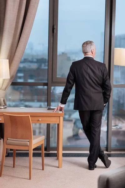Гордий старший бізнесмен відображає біля вікна — стокове фото
