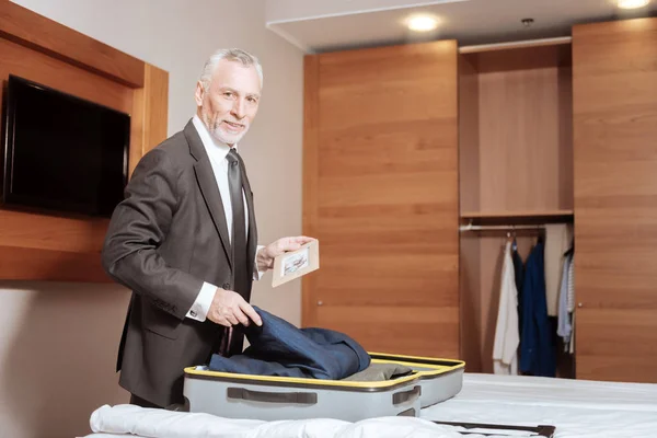 Gay senior man tar saker ur resväska — Stockfoto