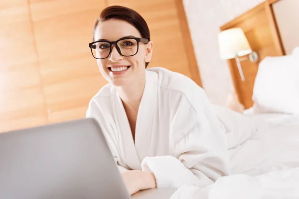 Feliz mujer agradable trabajando en la cama — Foto de Stock