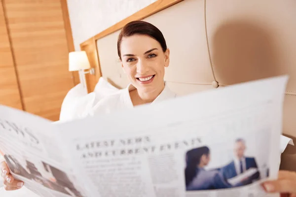 Jolly succesvolle vrouw onderzoekend krant — Stockfoto