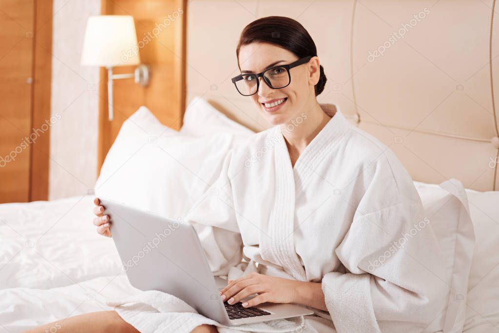 Gorgeous merry woman sitting with laptop
