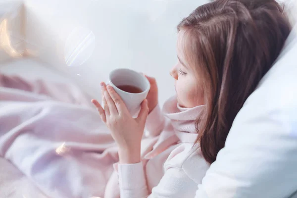 Foto de perfil del niño enfermo que sostiene la taza con té — Foto de Stock