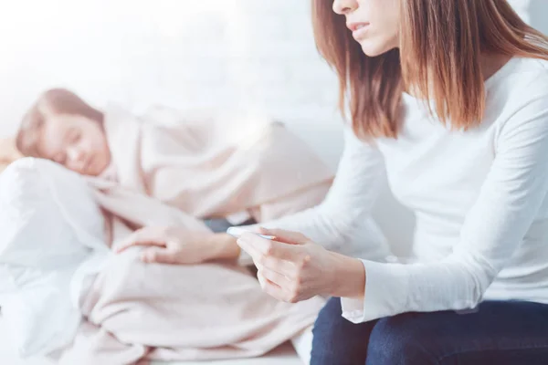 Anxious woman sitting near her ill daughter — Stock Photo, Image