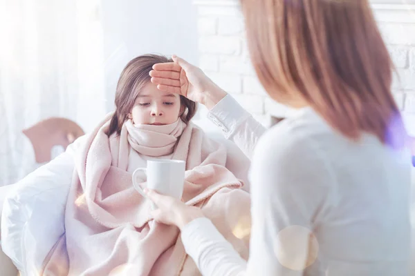 Attentive mother treating her sick daughter — Stock Photo, Image