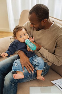 Gülümseyen baba oğlunun besleme