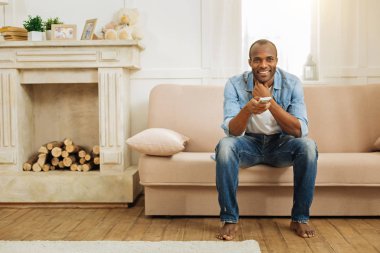 Güzel gülümseyen adam kanepede rahatlatıcı