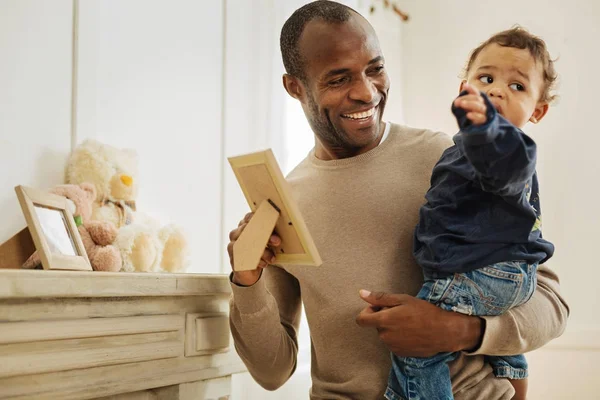 Sonriente padre mostrando fotos a su hijo —  Fotos de Stock