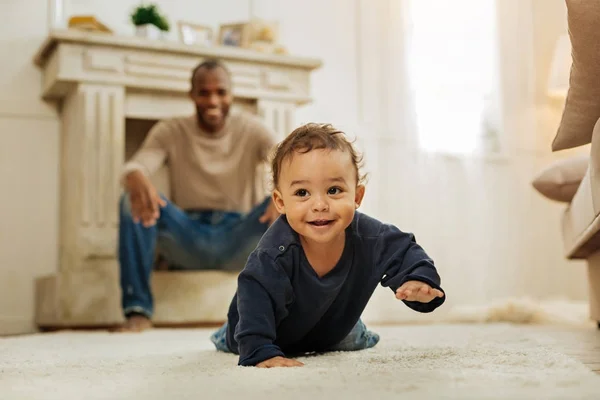 Sorrindo pai assistindo seu filho rastejando — Fotografia de Stock