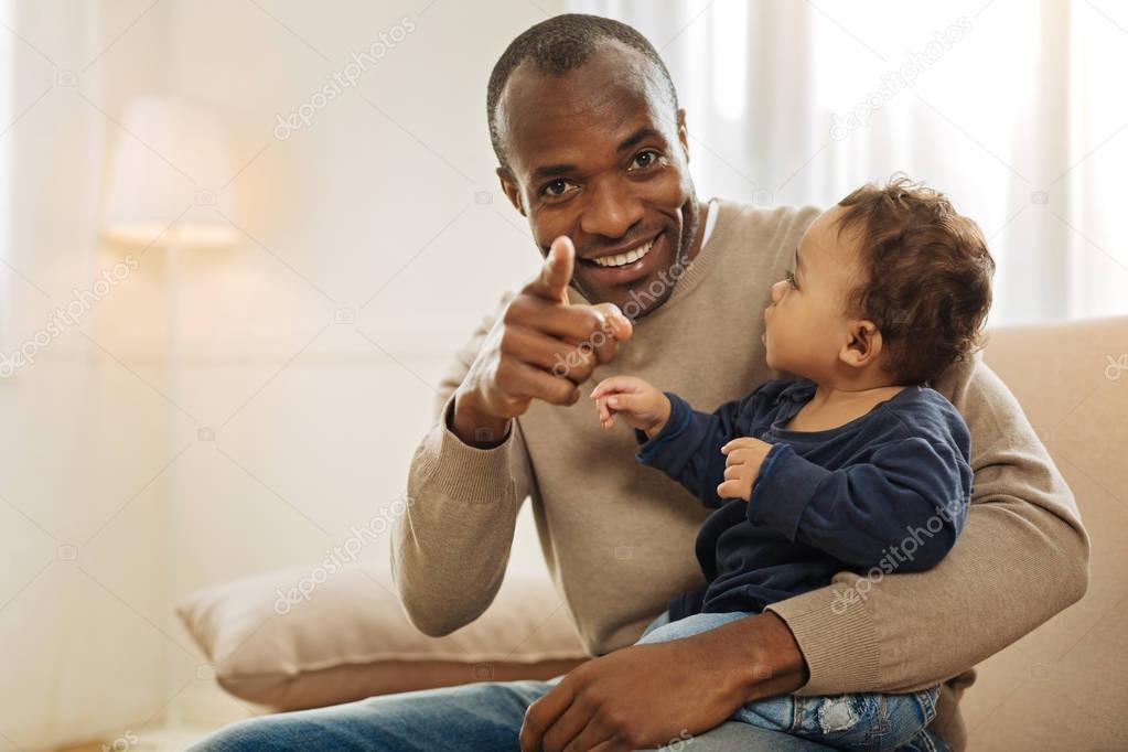 Smiling man holding a baby