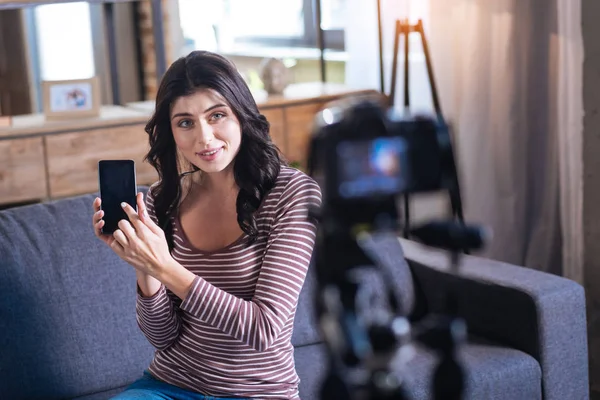 Mujer joven agradable mostrando su teléfono inteligente — Foto de Stock