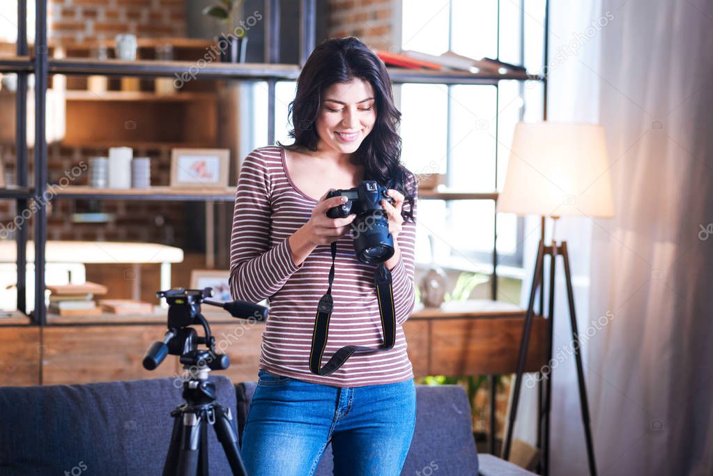 Cheerful delighted woman holding a camera