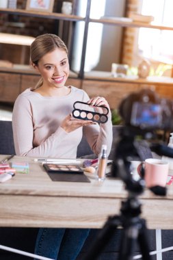 Göz farı paleti tutan olumlu memnun kadın