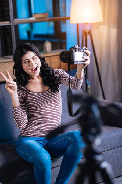 Happy delighted woman showing V sign