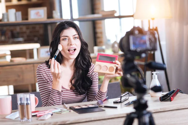 Mujer atractiva positiva haciendo maquillaje — Foto de Stock