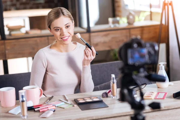 Happy cheerful woman holding a makeup brush — Stock Photo, Image