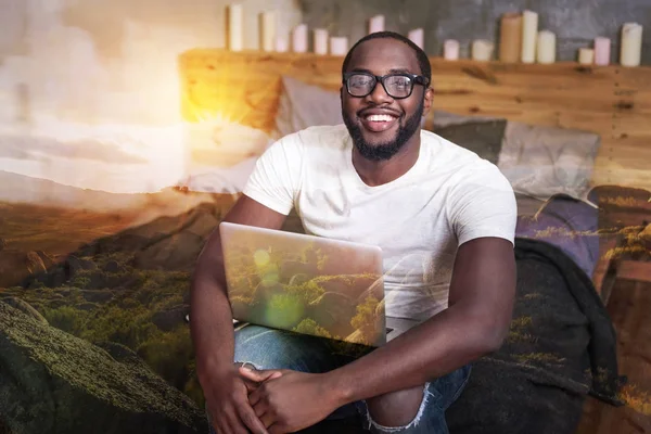 Alegre hombre positivo sosteniendo su portátil — Foto de Stock