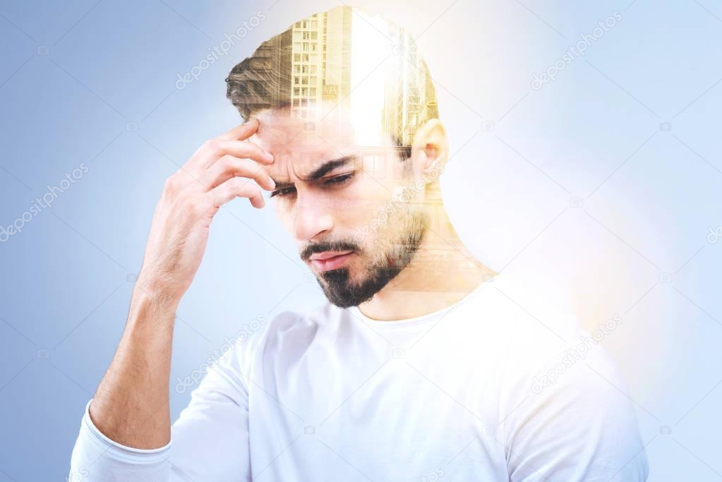 Thoughtful young man holding his forehead