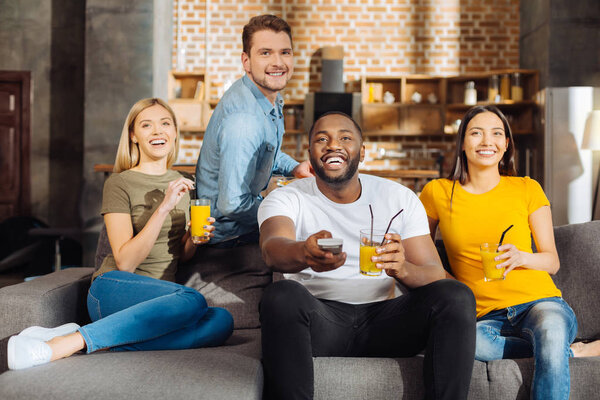 Четыре привлекательных весёлых друга смотрят кино
