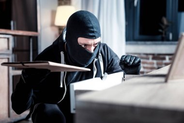 Masked burglar committing a crime clipart