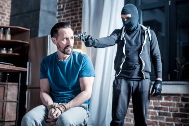 Kafa adamın için bir tabanca tutan maskeli ceza