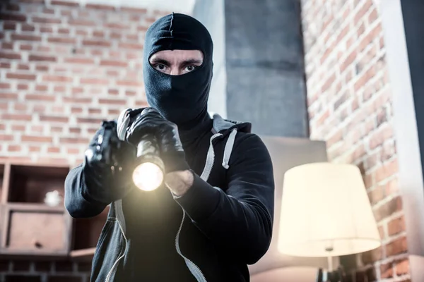 Irriterad maskerade rånare håller en fackla — Stockfoto