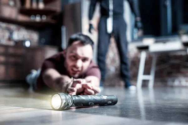 Scared man reaching for a torch — Stock Photo, Image