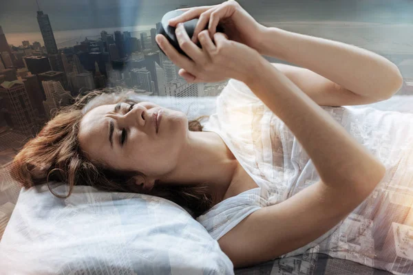 Trött kvinna som tittar på hennes väckarklocka — Stockfoto