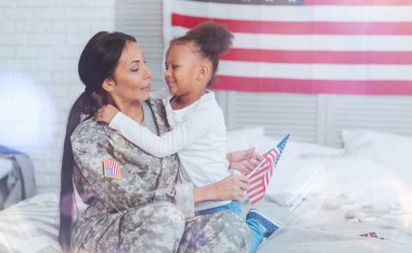 Pozitif güzel anne ve kızı yatağa oturmuş