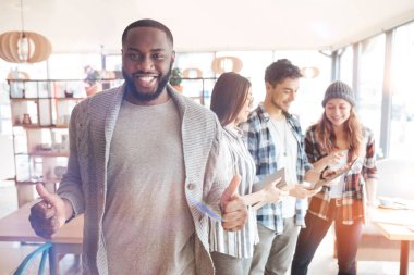 Başparmak kadar yükselterek memnun siyah adam